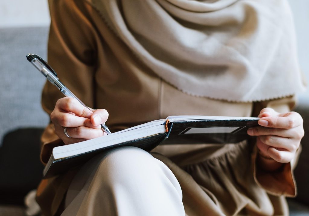 Muslim, woman, writing — Essential Construction Project Management Tools Every Contractor Needs